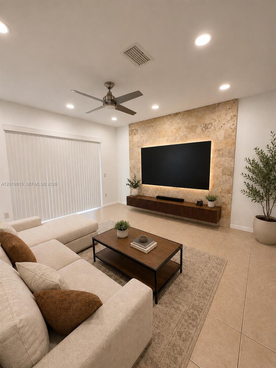 A living room features a stone accent wall with a mounted television and floating console — 1820 SW 89th Ter, Miramar FL 33025, MIRAMAR, FL