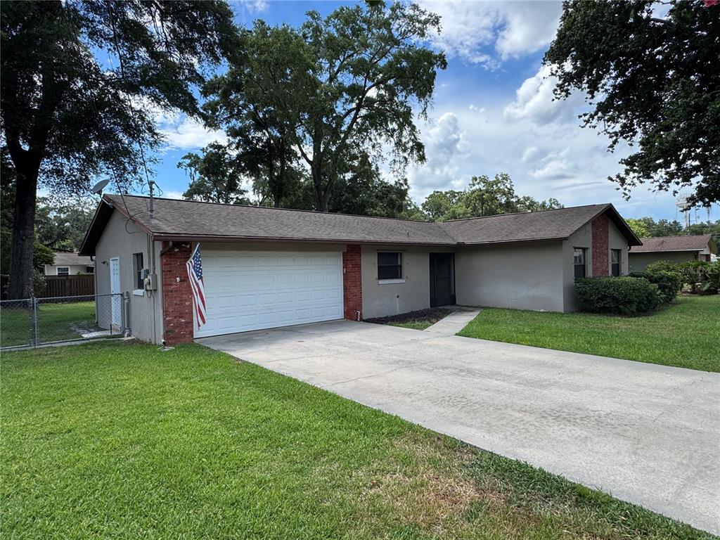 A single-story house with a white garage door, brick accents, and a concrete driveway — 4080 NE 28TH TERRACE, OCALA, FL
