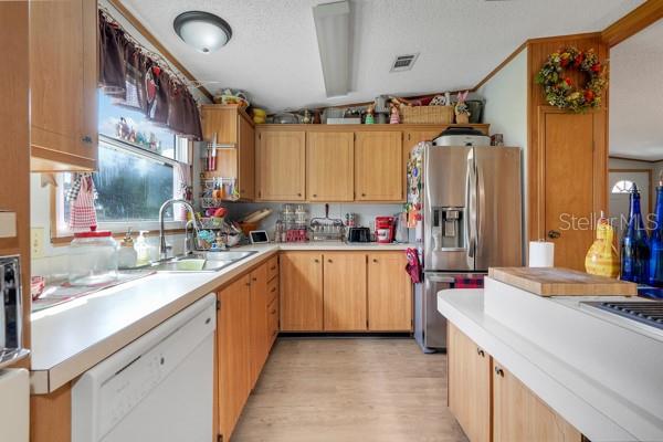 A kitchen with light wood cabinets, white countertops, stainless steel appliances, and a window — 357 WADE PARK COURT, DAVENPORT, FL
