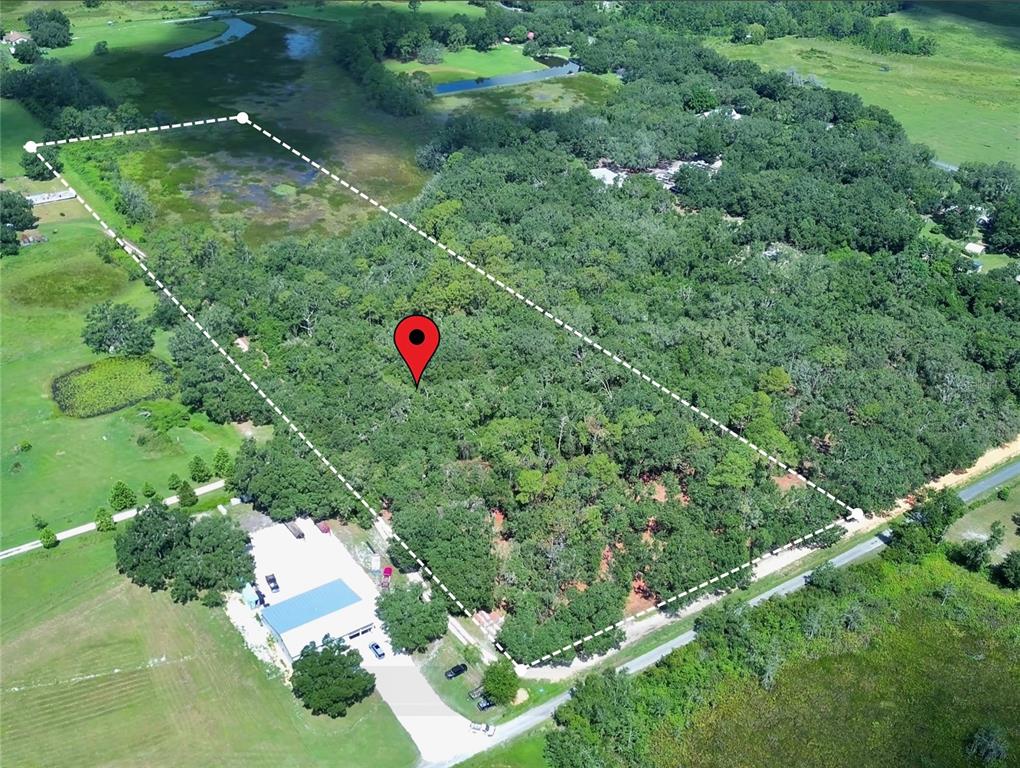 A dirt road runs between a fenced grassy area and a line of trees — 2 SENDCASTLE DRIVE, GROVELAND, FL