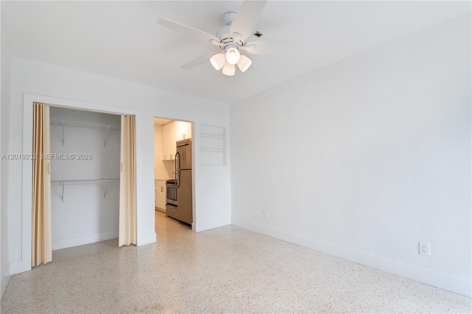 A room with white walls, a ceiling fan, a closet, and a view into a kitchen — 1450 SW 6th St # 9, Miami FL 33135, MIAMI, FL
