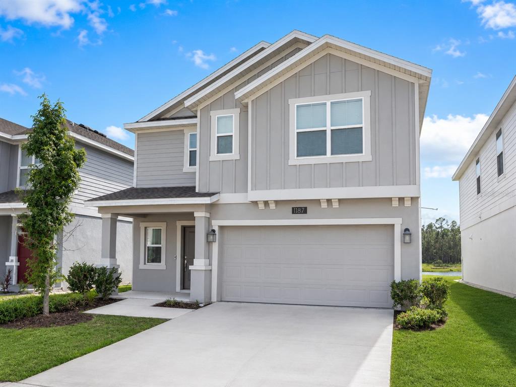 A two-story house with gray siding, a two-car garage, and a concrete driveway — 1187 CABOT CLIFFS DRIVE, DAYTONA BEACH, FL