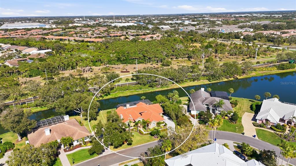 An aerial view shows a house with a red tile roof beside a canal — 4221 ESCONDITO CIRCLE, SARASOTA, FL