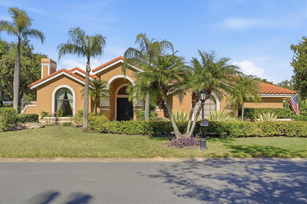 A single-story stucco house with a tile roof and palm trees in the front yard — 4221 ESCONDITO CIRCLE, SARASOTA, FL