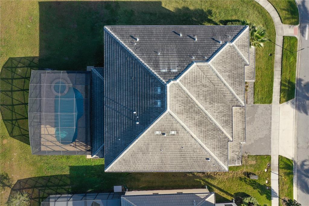 An aerial view shows a house with a tiled roof, a pool enclosure, and driveway — 3801 SONOMA BOULEVARD, KISSIMMEE, FL