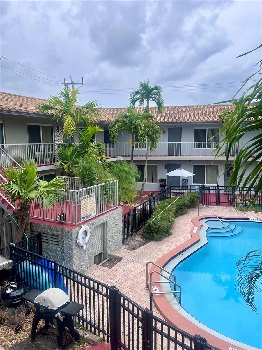 An outdoor swimming pool is situated in the courtyard of a two-story apartment complex — 915 SE 22nd Avenue, Pompano Beach FL 33062, POMPANO BEACH, FL