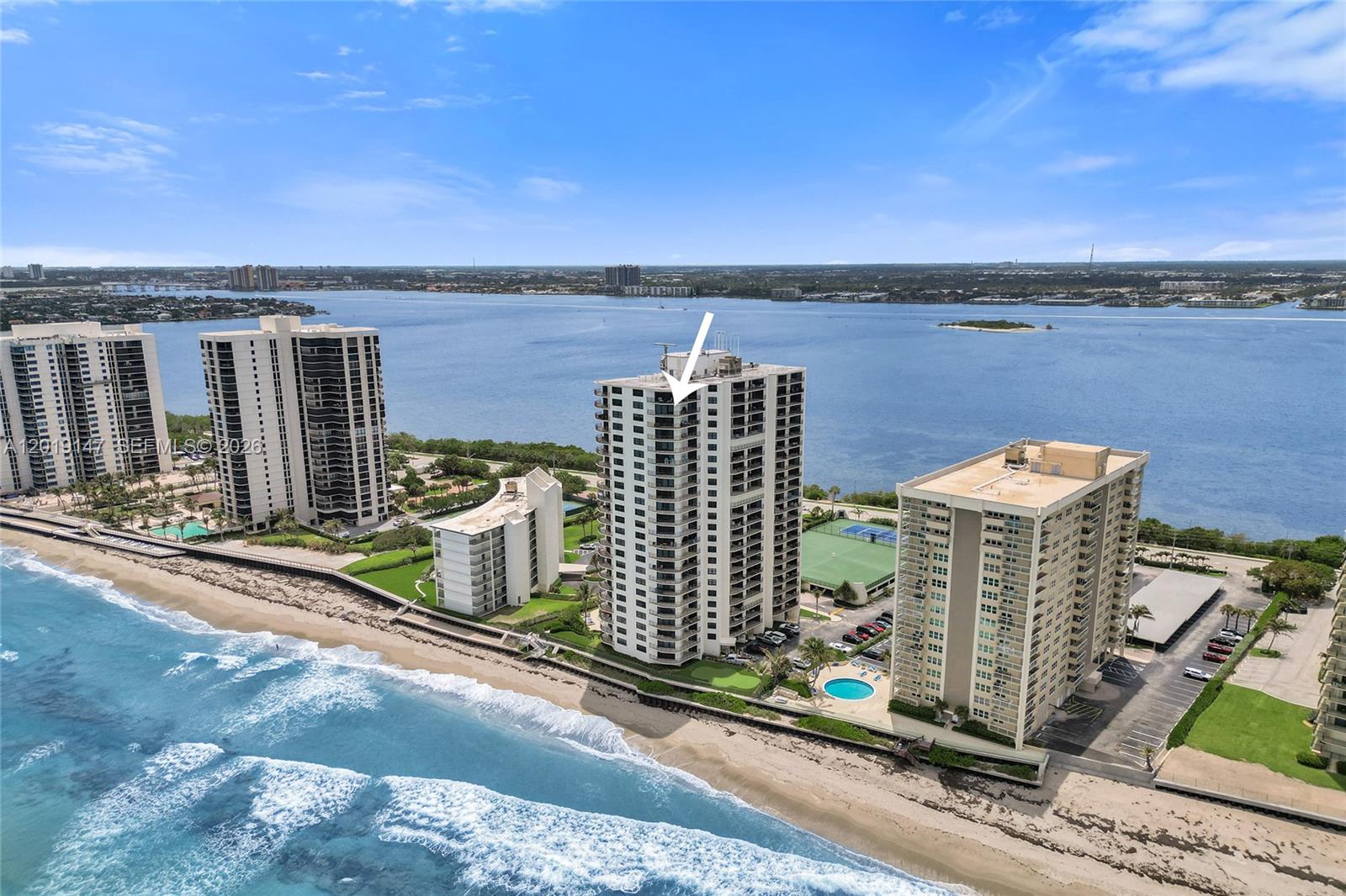 An aerial view shows several high-rise residential buildings situated along a sandy beach — 5420 N Ocean Dr # 2201, Singer Island FL 33404, SINGER ISLAND, FL
