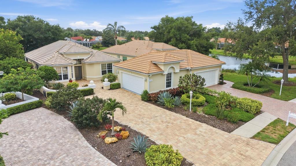 An aerial view of a single-story house with a tiled roof and a paved driveway — 7235 KENSINGTON COURT, UNIVERSITY PARK, FL