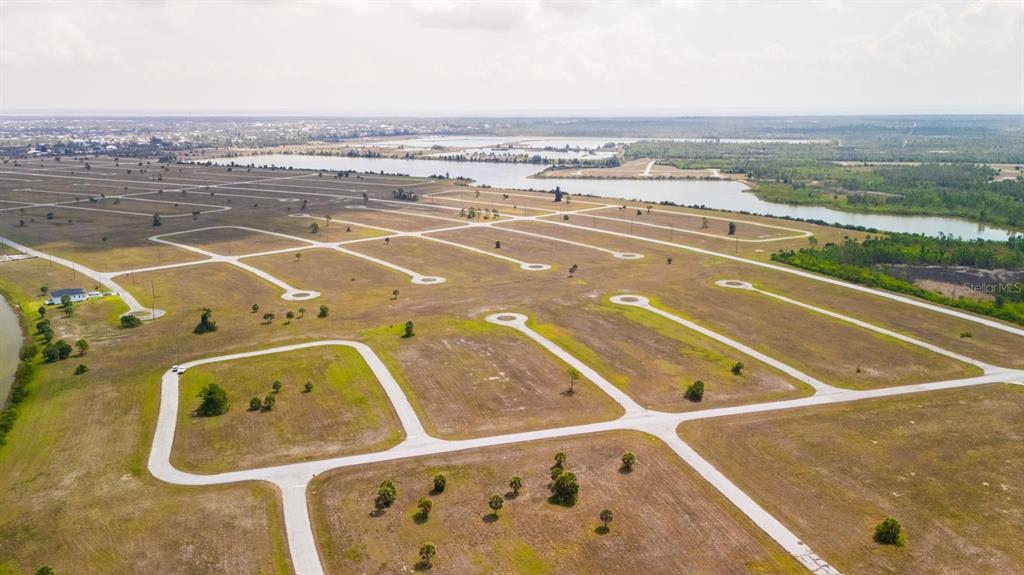 An aerial view shows a large, undeveloped residential subdivision with paved roads and cul-de-sacs — 14163 PERMIT COURT, PLACIDA, FL