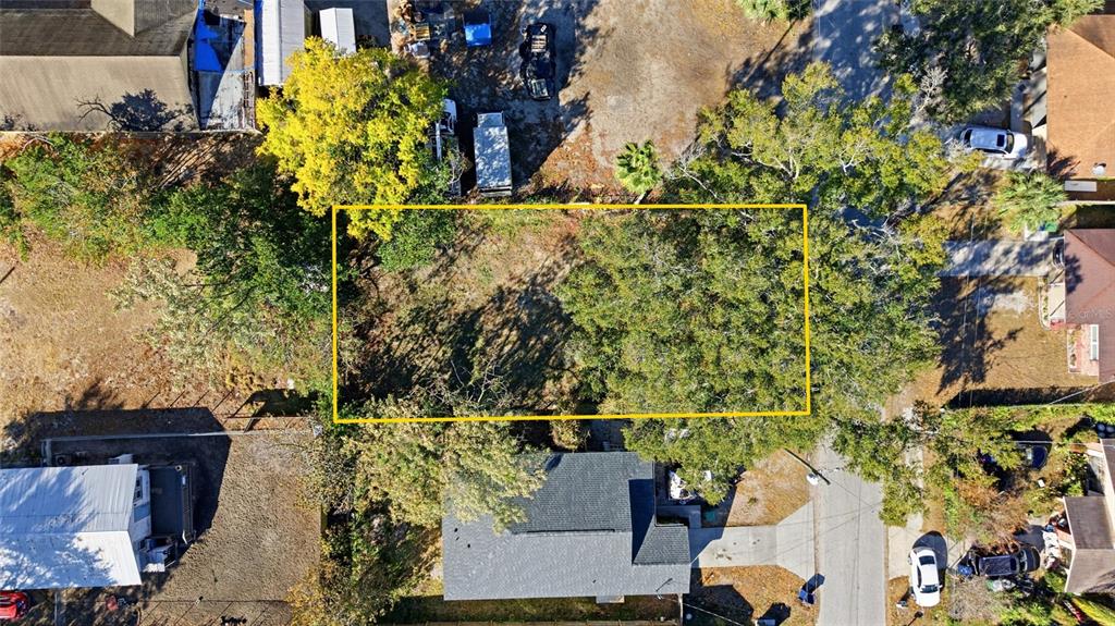 An aerial view shows a rectangular vacant lot outlined in yellow between existing residential properties — 3405 E POWHATAN AVENUE, TAMPA, FL