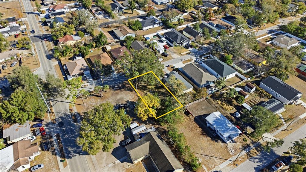 An aerial view shows a vacant rectangular lot outlined in yellow within a residential neighborhood — 3405 E POWHATAN AVENUE, TAMPA, FL