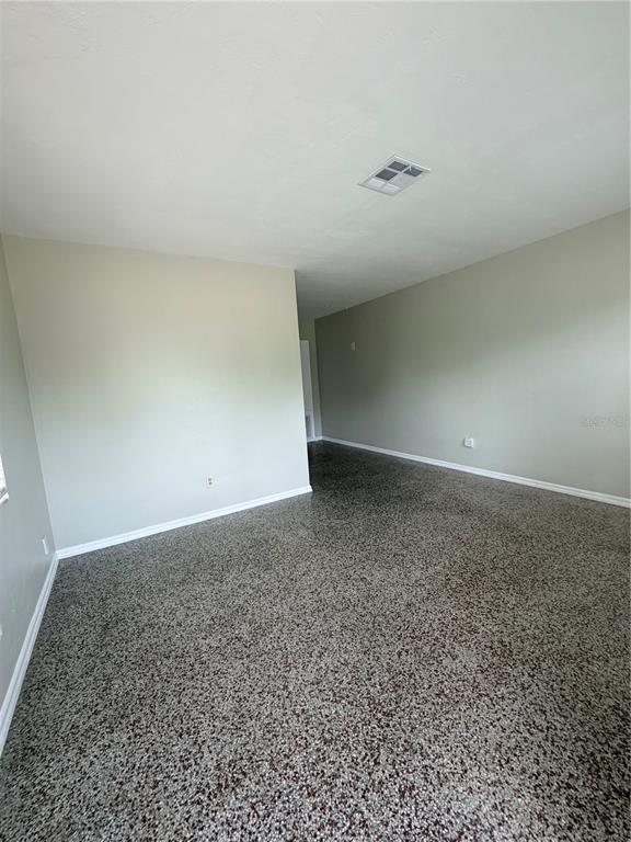 An empty room features light-colored walls and a speckled, epoxy-style floor finish — 13 W PRINCETON STREET UNIT 15, ORLANDO, FL