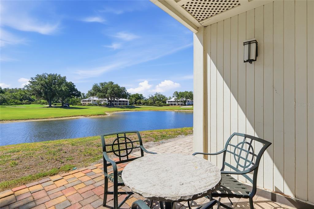 A patio with a table and chairs overlooks a pond and a golf course — 29300 BAY HOLLOW DRIVE UNIT 3257, WESLEY CHAPEL, FL