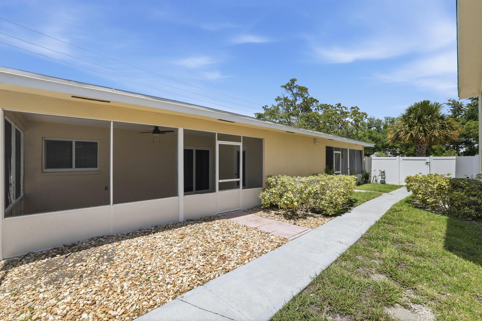 A yellow house features a screened-in porch, a gravel patio, and a concrete walkway — 1880 SE 3rd Street # 1880, Pompano Beach FL 33060, POMPANO BEACH, FL