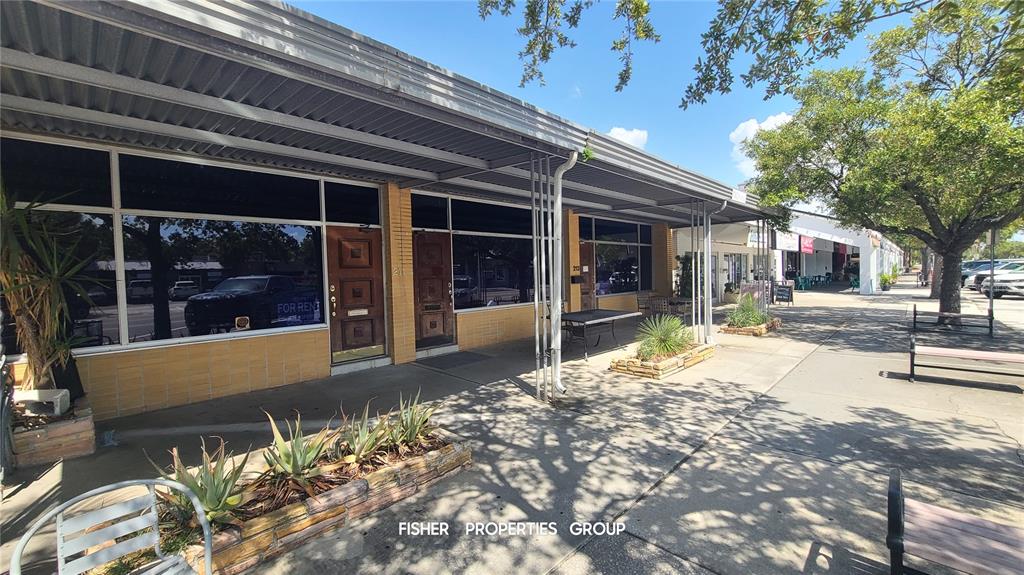 A commercial storefront with a covered walkway, brick facade, and large display windows — 211-213 E DAVIS BOULEVARD, TAMPA, FL