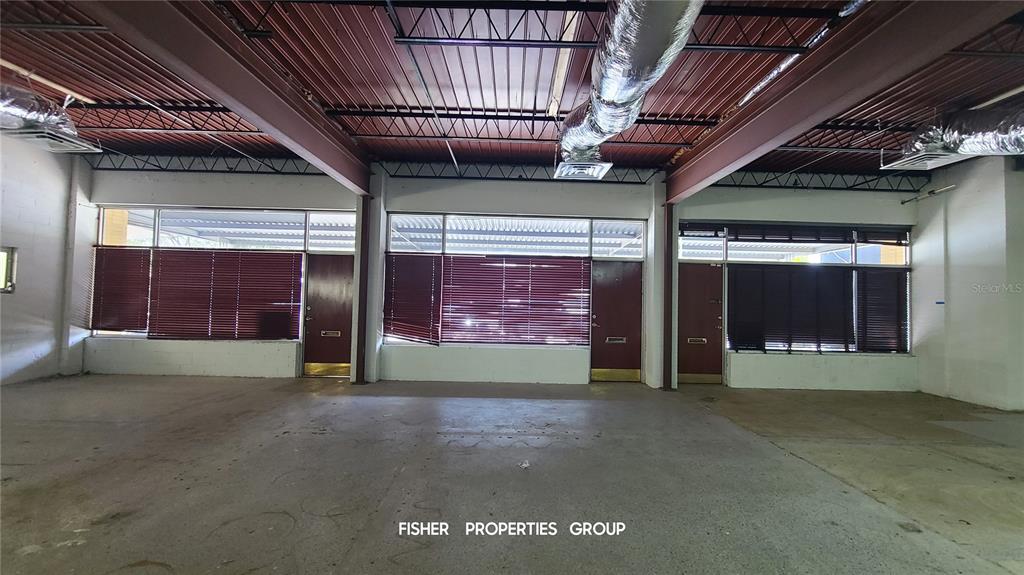 An interior view of a commercial space with exposed ceiling beams, ductwork, and large windows — 211-213 E DAVIS BOULEVARD, TAMPA, FL