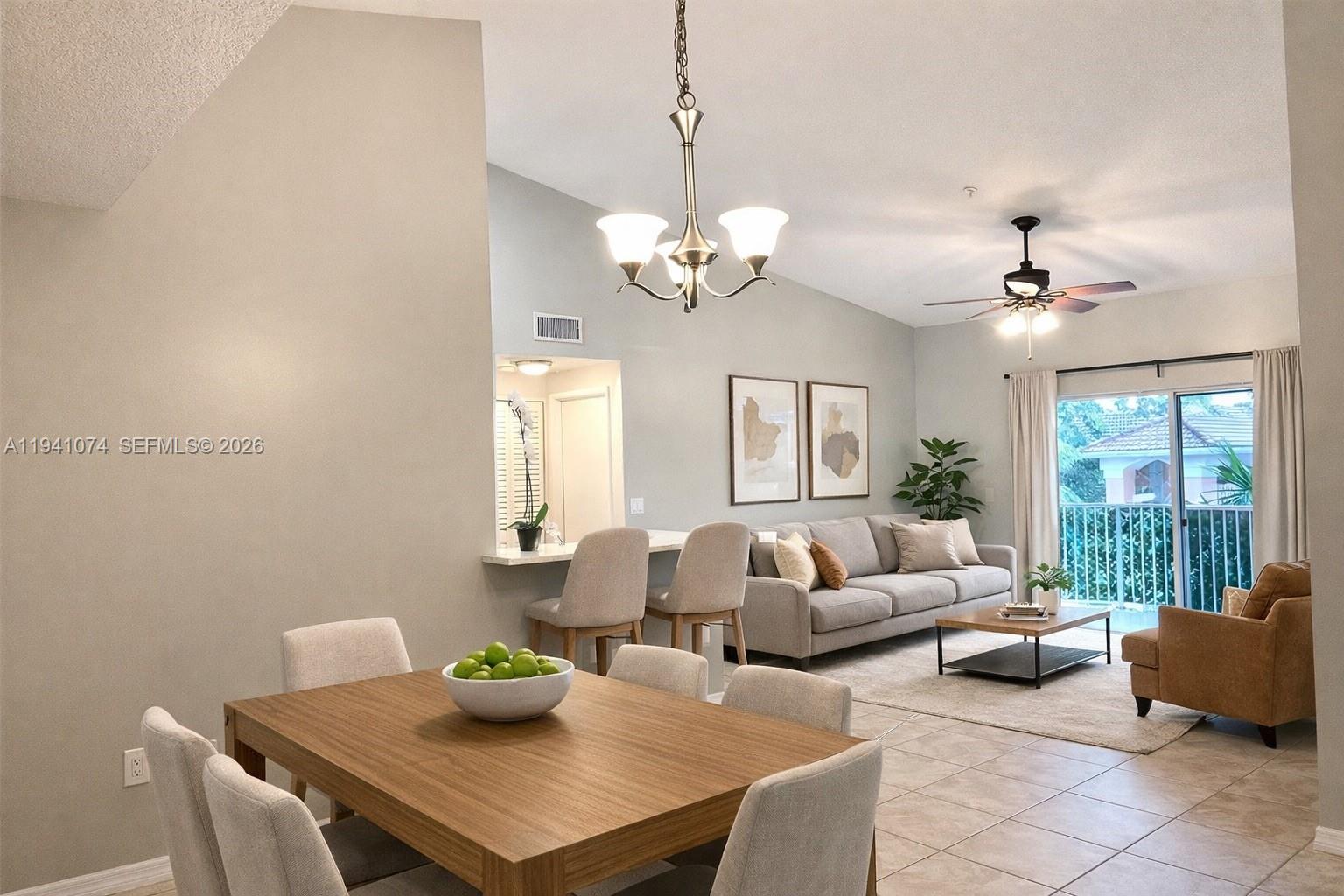 A dining area and living room feature neutral furniture, a chandelier, and a balcony view — 6928 SW 39th St # A304, Davie FL 33314, DAVIE, FL