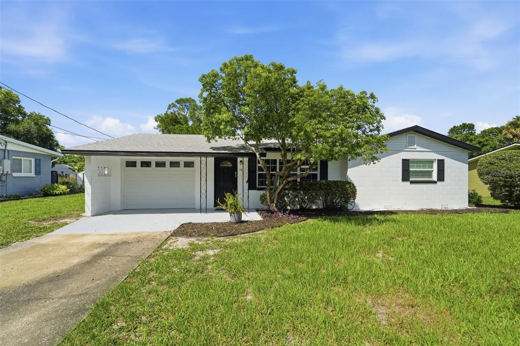 A single-story white house with a garage, a front tree, and a grassy lawn — 16 OLEANDER LANE, DEBARY, FL