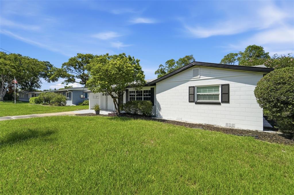 A white, single-story concrete block house with a dark roof and black window shutters — 16 OLEANDER LANE, DEBARY, FL