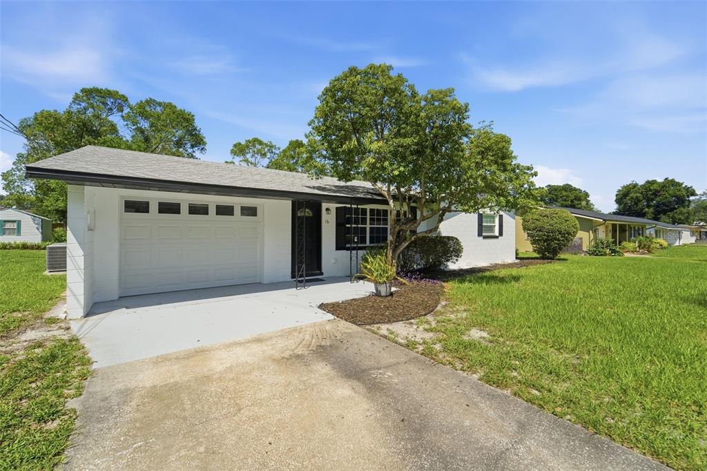 A white single-story house with a one-car garage and a concrete driveway — 16 OLEANDER LANE, DEBARY, FL