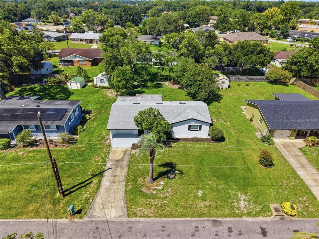 An aerial view shows a single-story house with a gray roof, driveway, and large lawn — 16 OLEANDER LANE, DEBARY, FL