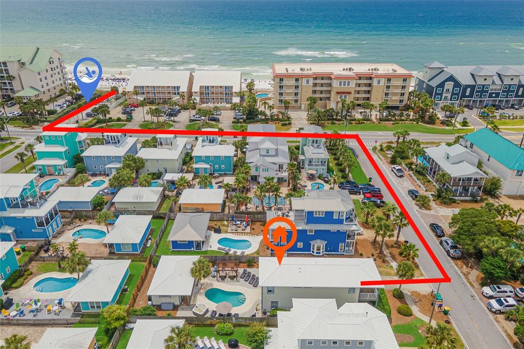 This aerial view shows a coastal neighborhood with houses, private pools, and a beach nearby — 79 MARK STREET, DESTIN, FL