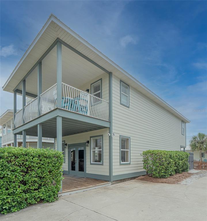 A two-story house with light-colored siding, a covered ground-level patio, and an upper-level balcony — 79 MARK STREET, DESTIN, FL