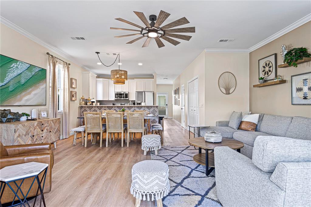 An open-concept living and dining area features wood-look flooring, a large ceiling fan, and furniture — 79 MARK STREET, DESTIN, FL