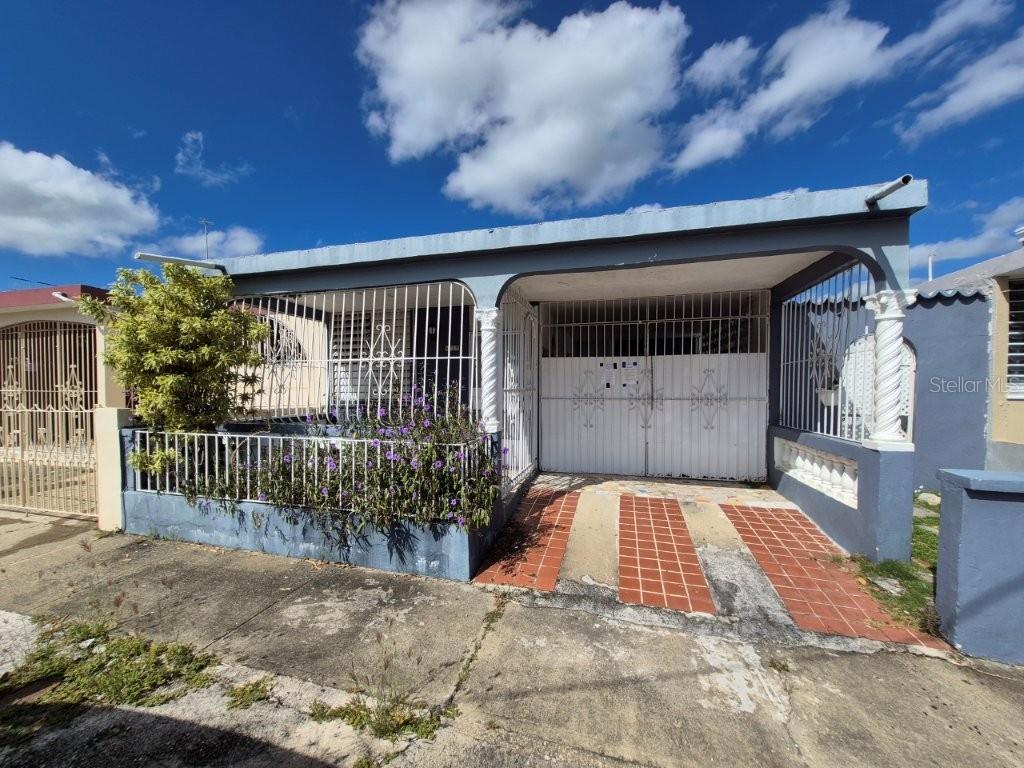 A single-story house with a blue exterior, a gated carport, and a small front garden — 4219 CALLE SANTA MONICA, PONCE, PR