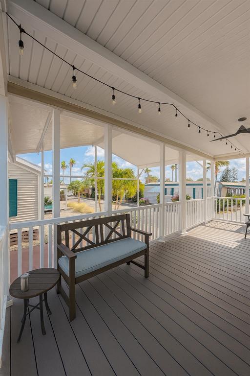 A covered porch features a wooden bench, a small side table, and string lights — 1375 PASADENA AVENUE S UNIT 217, SOUTH PASADENA, FL