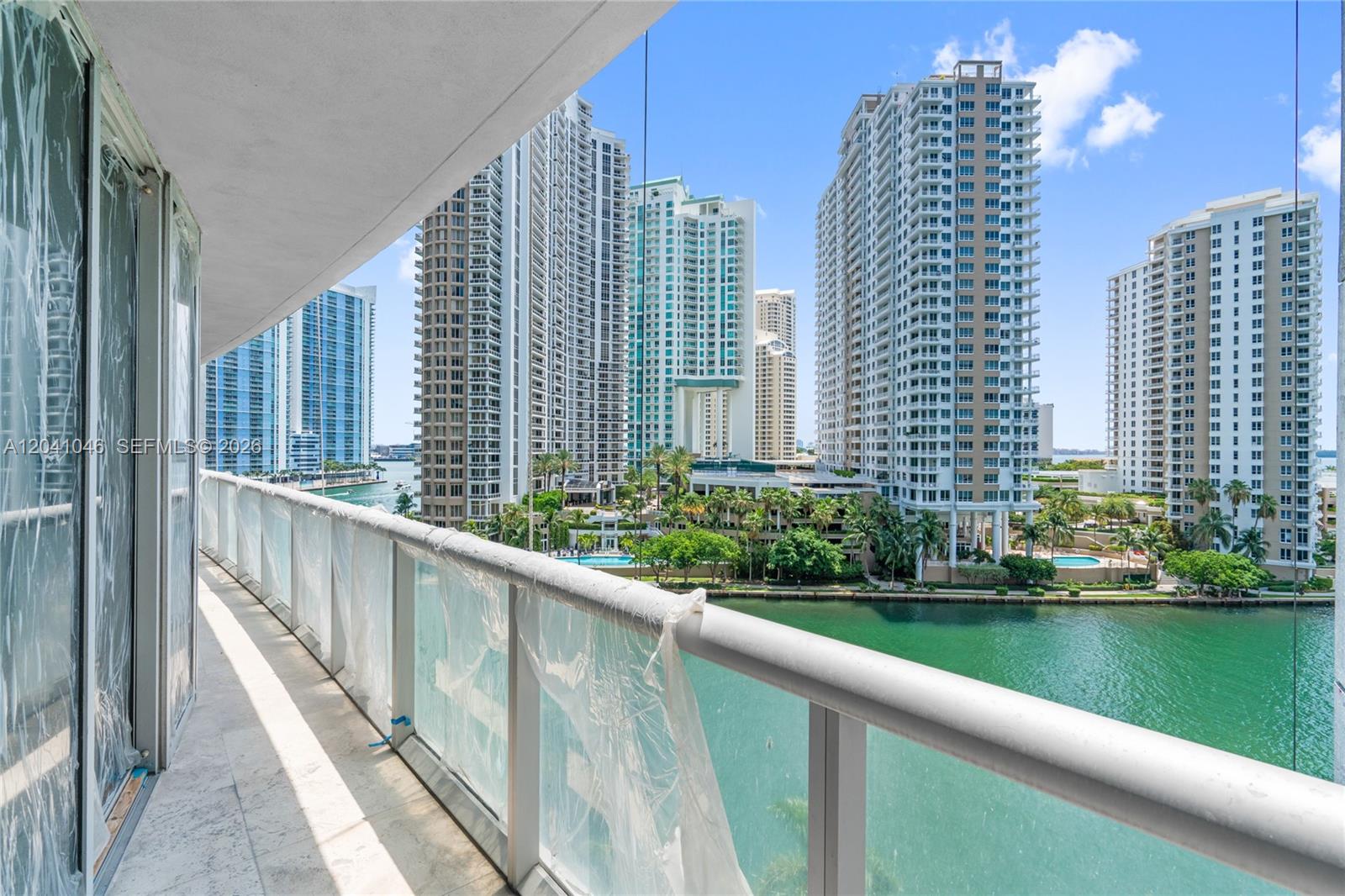 A high-rise balcony overlooks a canal surrounded by several tall residential apartment buildings — 495 Brickell Ave, Miami FL 33131, MIAMI, FL