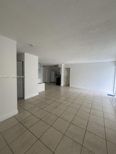 An open-concept living area features white walls, a tiled floor, and a view of the kitchen — 6901 Thomas St, Hollywood FL 33024, HOLLYWOOD, FL