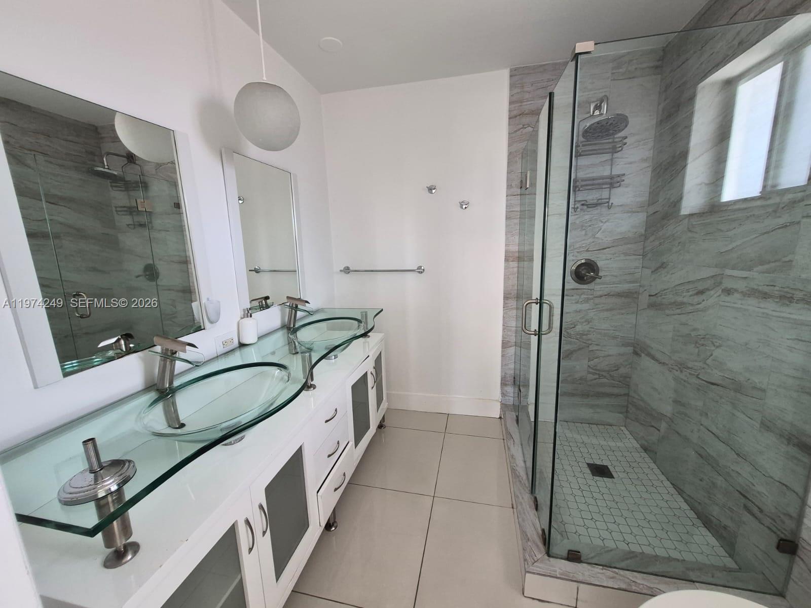 A kitchen features dark wood cabinets, granite countertops, stainless steel appliances, and light tile flooring — 1240 NE 83rd St # 1240, Miami FL 33138, MIAMI, FL