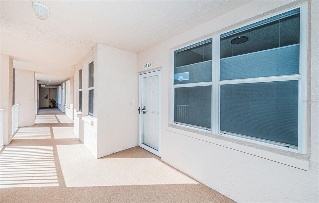 A covered outdoor walkway leads to a white front door with the number 9203 — 6450 SHORELINE DRIVE UNIT 9203, ST PETERSBURG, FL