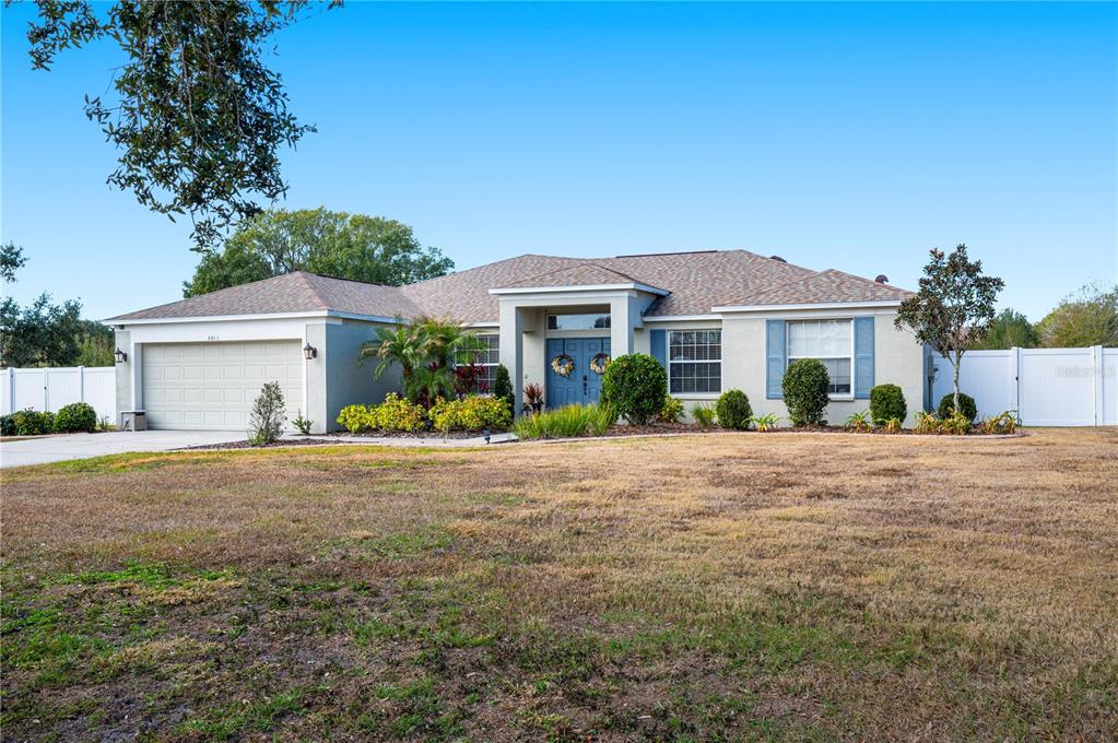 A single-story house with a two-car garage, blue front doors, and a large front yard — 4403 AVONDALE GROVES STREET, PLANT CITY, FL