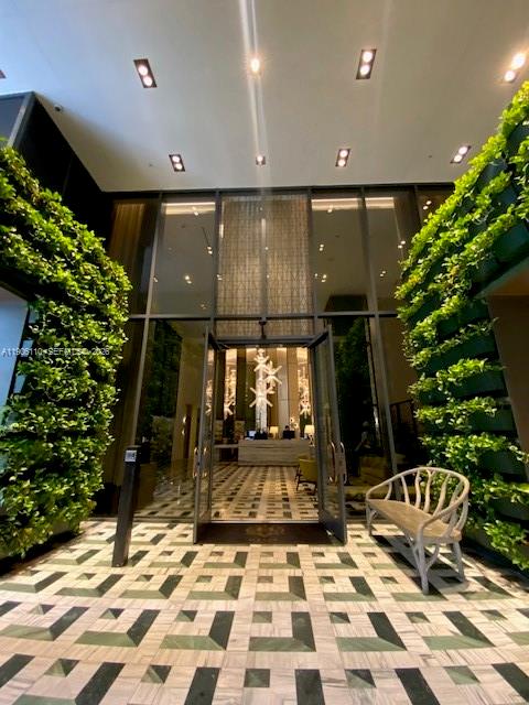A modern building lobby features a geometric tiled floor, vertical gardens, and a glass entrance — 801 S Miami Ave # 604, Miami FL 33130, MIAMI, FL