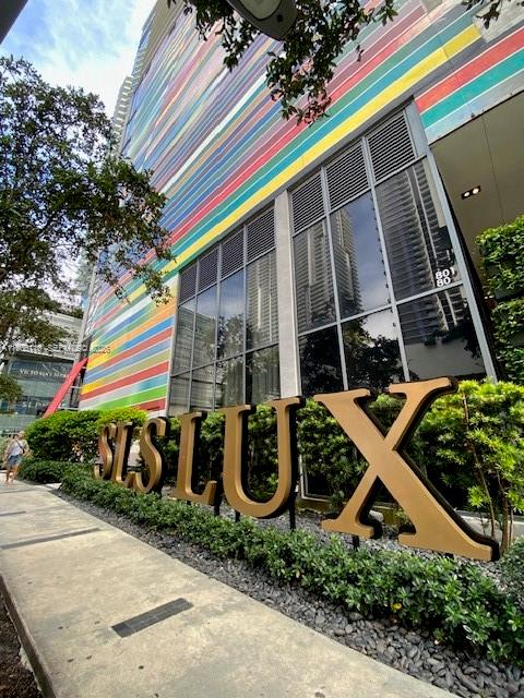 The exterior of a modern building features a colorful striped facade and large gold lettering — 801 S Miami Ave # 604, Miami FL 33130, MIAMI, FL