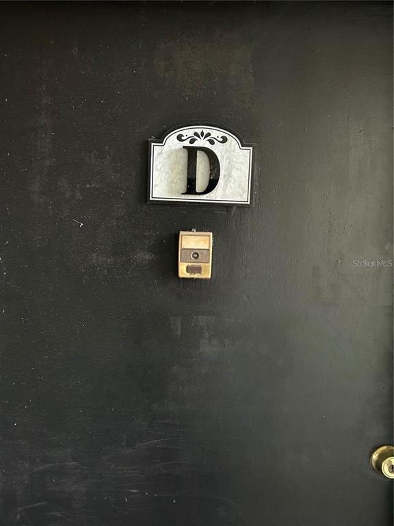 A black door features a decorative sign with the letter D and a doorbell — 946 LAKE DESTINY ROAD UNIT D, ALTAMONTE SPRINGS, FL
