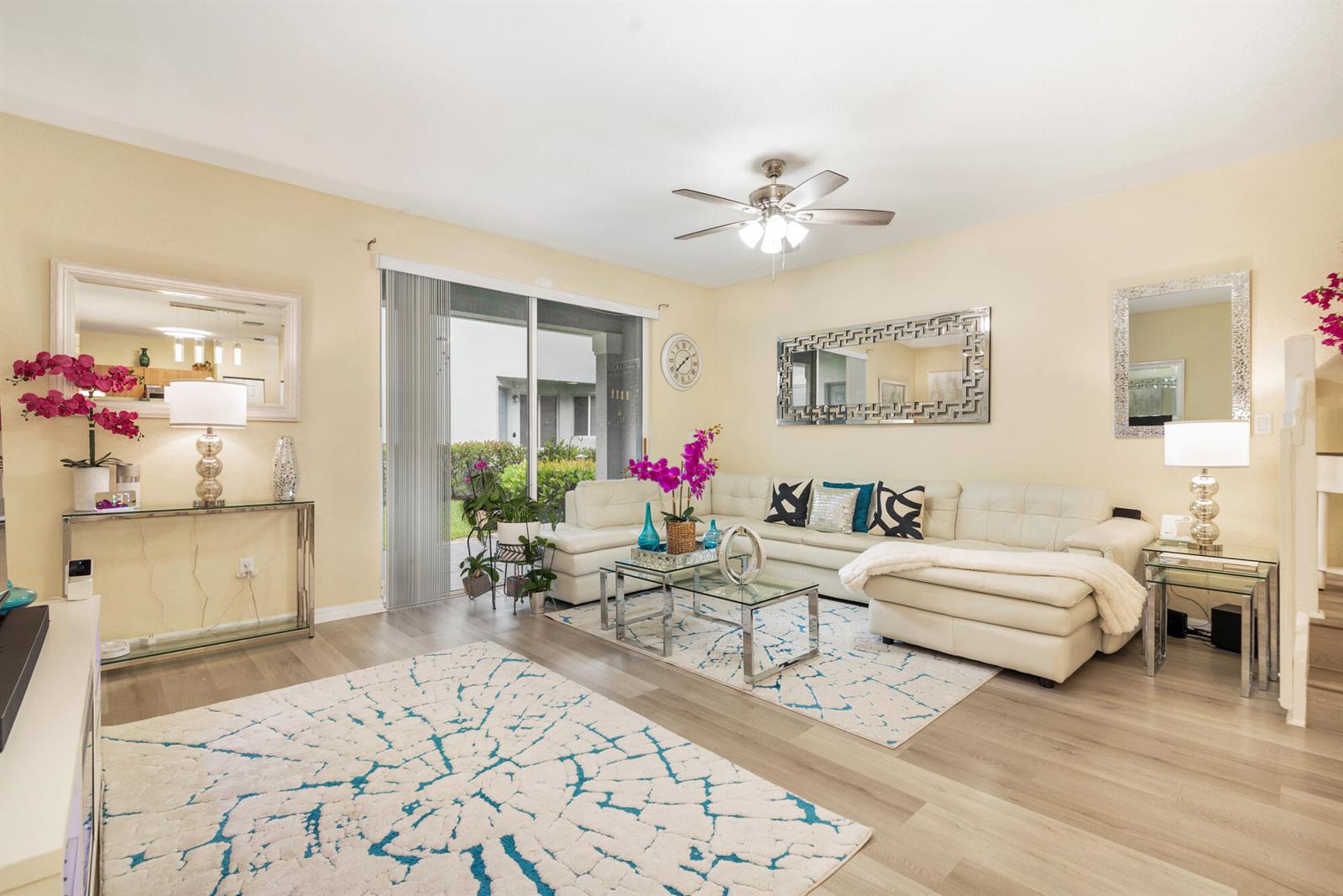 A living room features a white sectional sofa, glass coffee table, and sliding glass patio doors — 3725 Oleander Terrace, Riviera Beach FL 33404, RIVIERA BEACH, FL