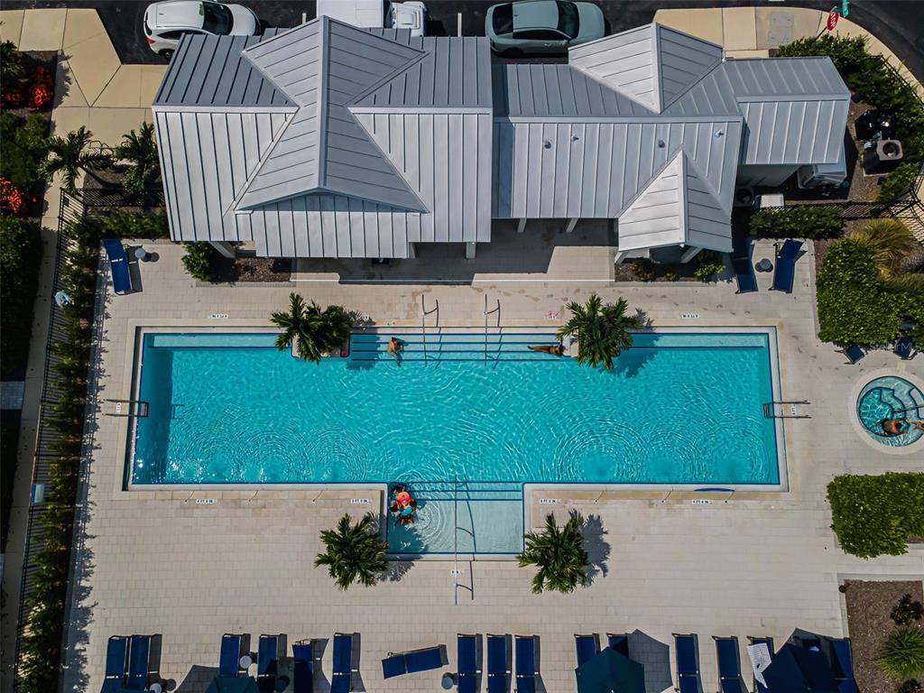 An aerial view shows a rectangular swimming pool with a sun shelf and adjacent hot tub — 2458 MANGUM COURT, SARASOTA, FL