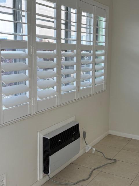 A room features white plantation shutters over a window and a wall-mounted air conditioning unit — 313 Andover # M, West Palm Beach FL 33417, WEST PALM BEACH, FL