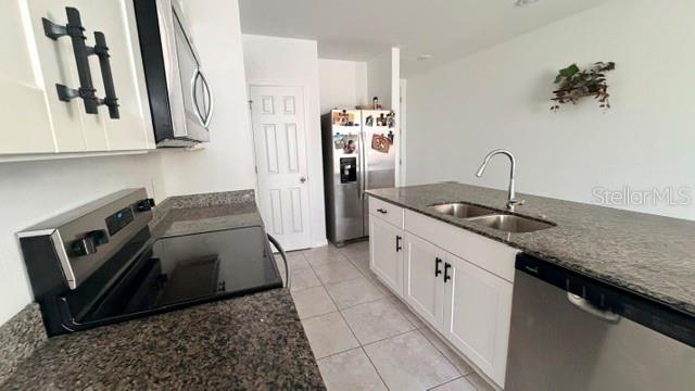 A kitchen features white cabinets, granite countertops, stainless steel appliances, and a tile floor — 4913 KAIA AVENUE, WINTER HAVEN, FL