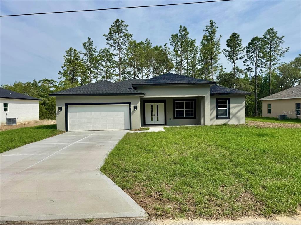 A single-story house with a two-car garage, light-colored stucco exterior, and a dark shingled roof — 152 W DIEGO PLACE, CITRUS SPRINGS, FL
