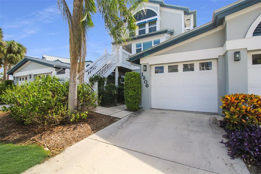 A multi-story house with a white garage, exterior staircase, and palm tree in the front yard — 1206 SIESTA BAYSIDE DRIVE UNIT 1206B, SARASOTA, FL
