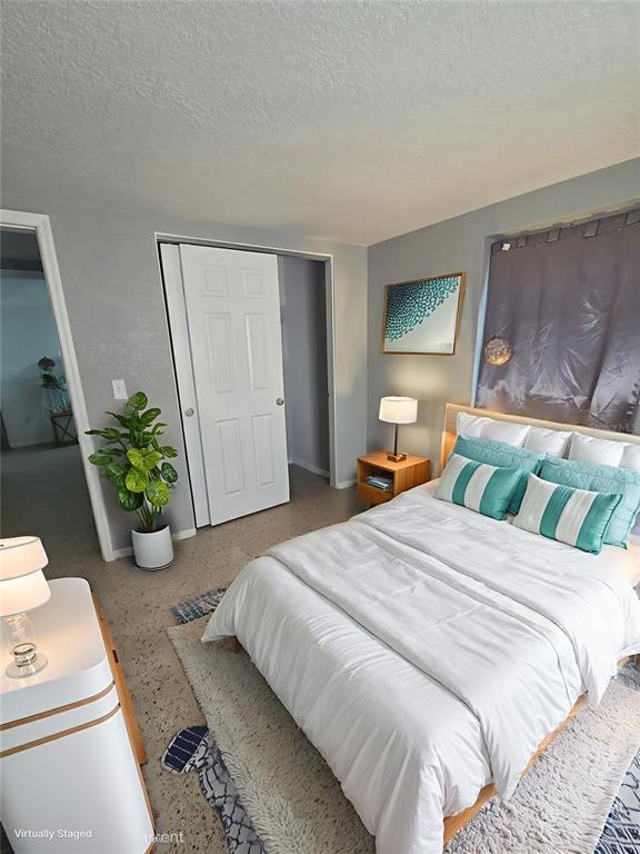 A bedroom features a bed with teal and white pillows, a nightstand, and a plant — 3007 15TH STREET W, BRADENTON, FL