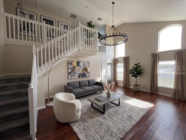 A living room features a staircase, a sofa, an armchair, and a large chandelier — 8103 TAR HOLLOW DRIVE, GIBSONTON, FL