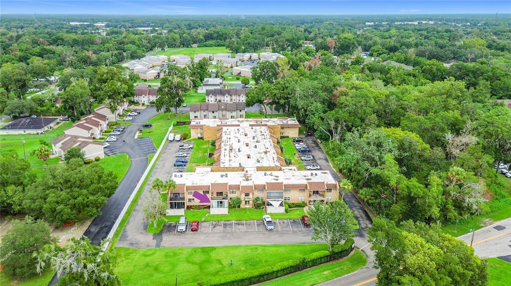 An aerial view shows a multi-story apartment building with a purple arrow pointing to a balcony — 2837 NE 3RD STREET UNIT 103, OCALA, FL