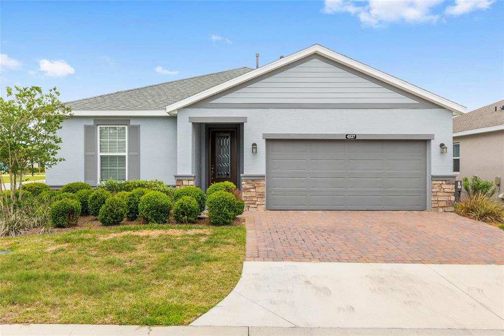 A single-story house with a gray exterior, stone accents, and a two-car garage — 4537 NW 53RD COURT, OCALA, FL