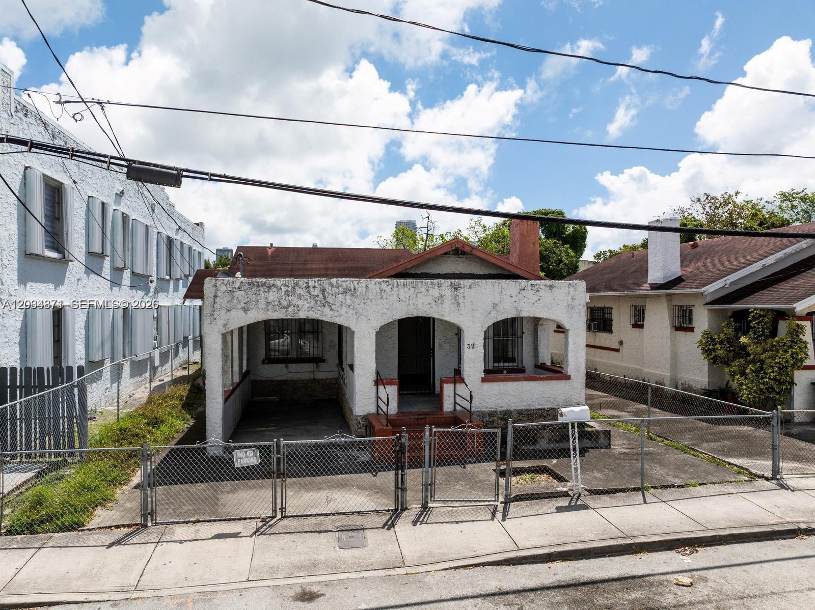 A single-story white stucco house with a front porch and a chain-link fence — 311 SW 10th Ave, Miami FL 33130, MIAMI, FL