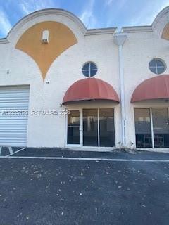 The exterior of a commercial building features two red awnings over glass storefront doors — 13850 SW 143rd Ct # 18, Miami FL 33186, MIAMI, FL
